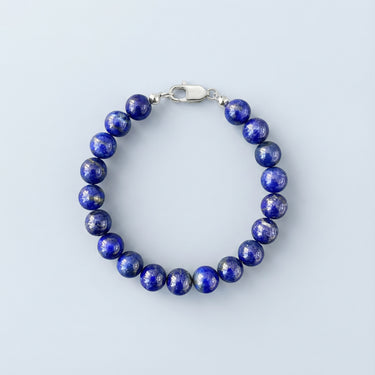 An 8mm Lapis Lazuli round bead bracelet with high-polish silver hardware, highlighting the natural stone texture.
