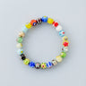 An 8mm handmade Millefiori glass bead bracelet featuring a kaleidoscope of floral patterns and a single 14k gold accent bead.
