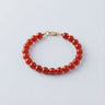 An 8mm Red Agate round bead bracelet with a high-polish gold lobster clasp, highlighting the smooth, polished surface of the gemstones.
