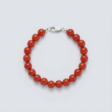 An 8mm Red Agate round bead bracelet featuring vibrant crimson stones and a high-polish silver lobster clasp, displayed against a light grey background.

