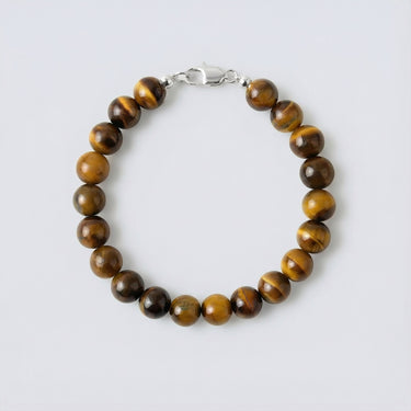 An 8mm Tiger's Eye round bead bracelet with a high-polish silver lobster clasp, highlighting the rich, banded textures of the stone.
