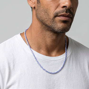 Man wearing a 3mm blue and white african chevron glass bead necklace with refined minimalist styling