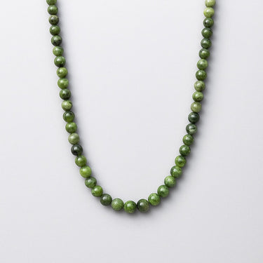A strand of 6mm forest-green Chrome Diopside beads displayed in a U-shape against a white background.
