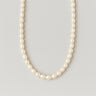 A single strand of 7-8mm white freshwater pearls displayed in a U-shape against a neutral light grey background.
