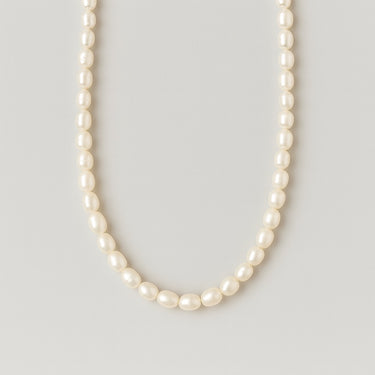 A single strand of 7-8mm white freshwater pearls displayed in a U-shape against a neutral light grey background.
