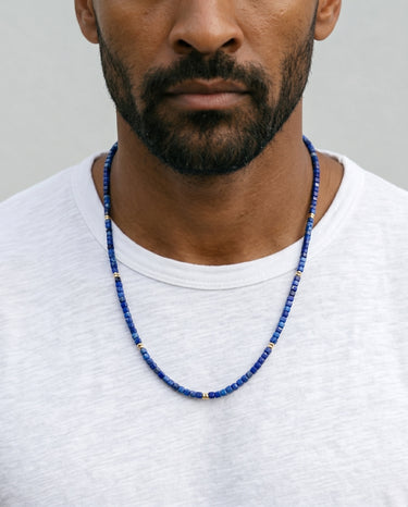 Man wearing a 3mm faceted lapis lazuli cube bead necklace with natural blue gemstones and gold-filled accent spacers.