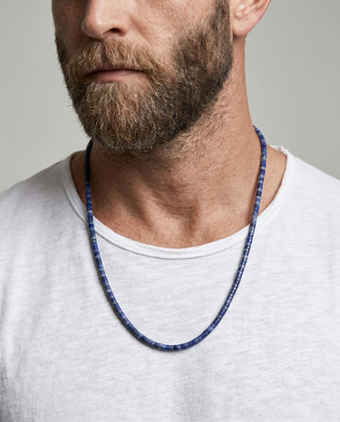 Men’s lapis lazuli heishi bead necklace with natural 4x2mm semi-precious stone beads on male model.
