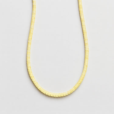 A front-facing view of a 4mm lemon jade heishi bead necklace showcasing the smooth, seamless transition between beads.
