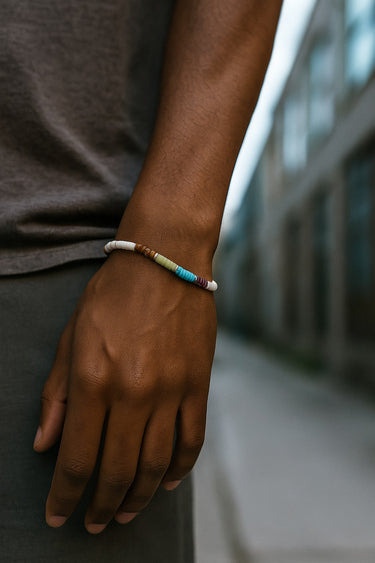 A close-up of a male model's wrist showcasing the eclectic, multi-tonal rhythm of a 4mm mixed gemstone heishi bead bracelet.
