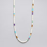 A strand of multi-colored heishi beads including turquoise, amethyst, and jade with sterling silver spacers, displayed in a U-shape.
