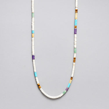 A strand of multi-colored heishi beads including turquoise, amethyst, and jade with sterling silver spacers, displayed in a U-shape.
