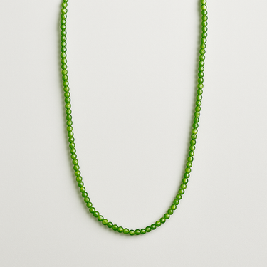 A strand of polished green jade beads displayed in a U-shape against a neutral white background.
