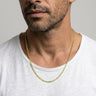 Man wearing a 2mm peridot faceted bead necklace against a plain background