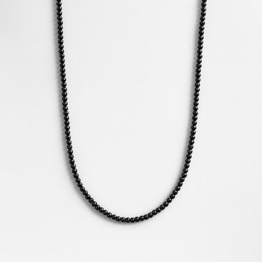 A strand of 4mm polished black onyx beads displayed in a U-shape against a bright white background.
