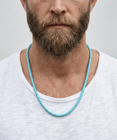Front view of a model wearing a 4mm turquoise heshi necklace styled with a white t-shirt.