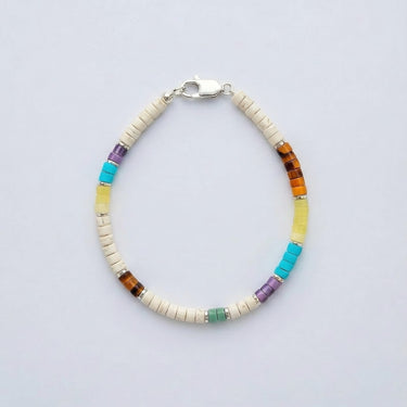 A product shot of a 4mm white heishi bracelet with multi-gemstone heishi beads, featuring turquoise, amethyst, aventurine, yellow jade, and tiger's eye with sterling silver roundel accents and a silver clasp.
