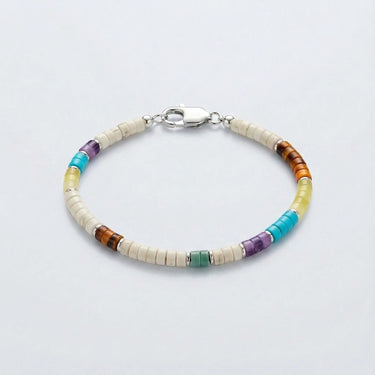 A lay flat product shot of a 4mm white heishi bracelet with multi-gemstone heishi beads, featuring turquoise, amethyst, aventurine, yellow jade, and tiger's eye with sterling silver roundel accents and a silver clasp.