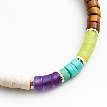 A macro close-up highlighting the transition between colorful gemstone heishi discs and polished sterling silver roundel accents.
