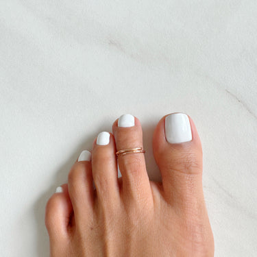 Foot model wearing 14K Rose-Gold Filled Adjustable Overlap midi Toe Ring on the middle toe. Slightly hammered to give texture and style.
