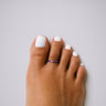 Purple anodized aluminum toe ring on toes — adjustable open-band fit, COLORS Collection by Clay & Chloe Jewelry.