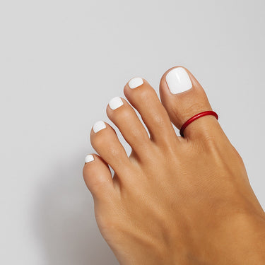 Red anodized aluminum big toe ring on toes — smooth rounded fit and bold color, COLORS Collection by Clay & Chloe Jewelry.
