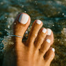 silver adjustable toe ring worn on a big toe in water, minimalist summer beach jewelry