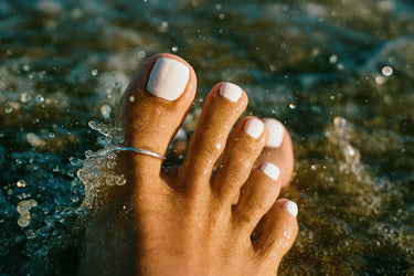 silver adjustable toe ring worn on a big toe in water, minimalist summer beach jewelry