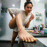 Woman showing off her toe ring with one foot on the bathroom counter 