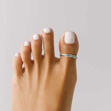 Sorbet blue anodized aluminum overlap big toe ring worn on model’s foot — smooth rounded fit, COLORS Collection by Clay & Chloe Jewelry.
