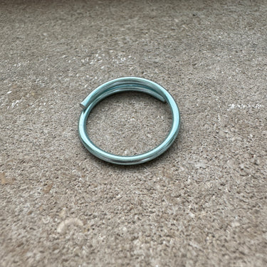 Inside view of sorbet blue anodized aluminum overlap toe ring displayed on concrete surface — lightweight water-friendly COLORS design.
