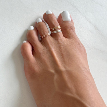 Foot model wearing 14K Rose-Gold Filled Adjustable Overlap mini Toe Ring. Slightly hammered to give texture and style.