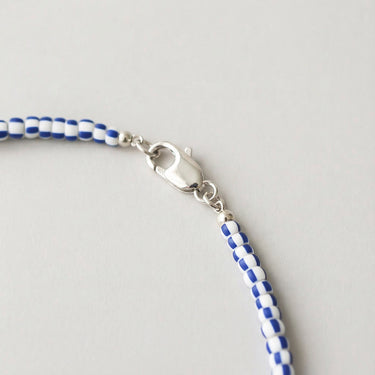 A macro close-up view of layered chevron glass beads finished with a high-polish silver lobster clasp.
