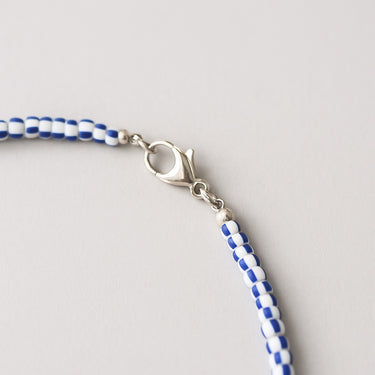 A macro detail view of the vintage chevron glass beads meeting professional-grade sterling silver hardware, featuring a secure and high-polish lobster clasp.
