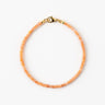A studio hero shot of a women's 2mm natural faceted golden sunstone cube bead bracelet with a 14K gold-filled clasp, highlighting the shimmering peach tones and delicate light-catching facets.

