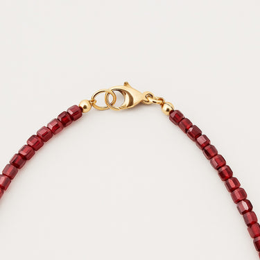 A macro detail view of the 3mm garnet cube beads meeting professional-grade 14K gold-filled hardware, featuring a secure and high-polish lobster clasp.
