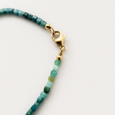 A macro close-up of the professional-grade 14K gold-filled lobster clasp and gold accent beads on the faceted Tourmaline cube necklace.
