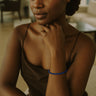 A close-up lifestyle view of the 3mm faceted lapis lazuli cube bracelet on a model’s wrist, emphasizing the delicate artisanal quality and vibrant blue color.
