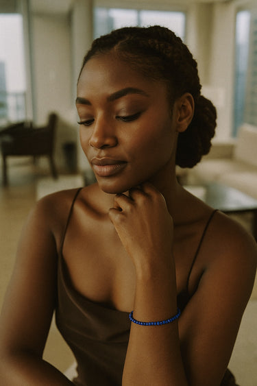 A close-up lifestyle view of the 3mm faceted lapis lazuli cube bracelet on a model’s wrist, emphasizing the delicate artisanal quality and vibrant blue color.

