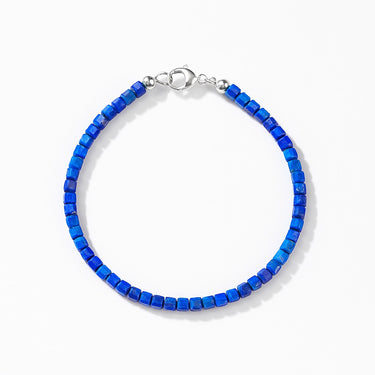 A studio hero shot of a women's 3mm natural faceted lapis lazuli cube bead bracelet with a sterling silver lobster clasp, highlighting the deep royal blue gemstone tones and light-catching geometric facets.
