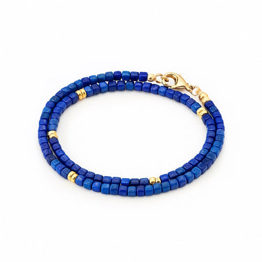 A studio hero shot of the 3mm faceted lapis lazuli cube wrap bracelet, showcasing the light-catching facets of the blue gemstones and high-shine 14K gold-filled accents.
