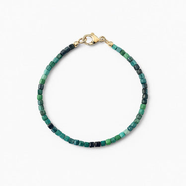 A studio hero shot of a women's 3mm natural faceted tourmaline cube bead bracelet with a 14K gold-filled clasp, highlighting the multi-tonal deep green and earthy gemstone hues.

