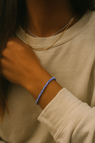 A portrait-view lifestyle shot of a model featuring the 3mm vintage African chevron glass bead bracelet, emphasizing its refined presence and historical artisanal influence.
