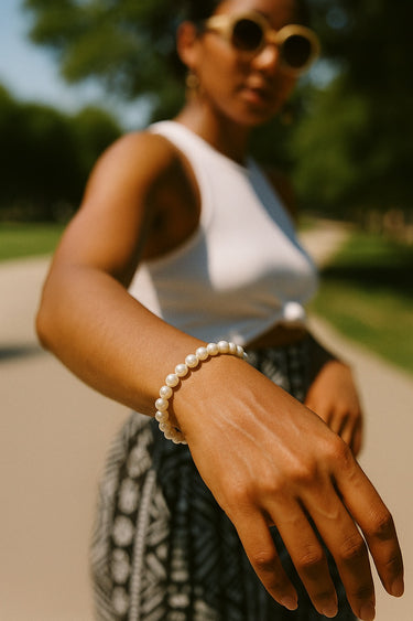 A lifestyle shot of a model wearing the 4-5mm baroque pearl bracelet in natural light, demonstrating its radiant glow and effortless, everyday luxury appeal.
