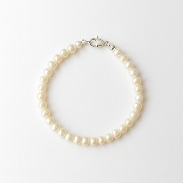 A studio hero shot of a 4-5mm natural white baroque freshwater pearl bracelet, showcasing the unique organic shapes and luminous luster of the dainty pearls.

