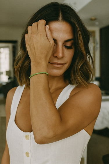 A portrait lifestyle shot of a model featuring the 4mm African green chrysoprase heishi bead bracelet, emphasizing its refined aesthetic and modern luxury appeal for everyday wear.