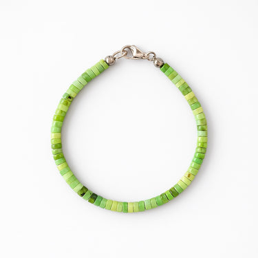 A studio hero shot of a 4mm African green chrysoprase heishi bead bracelet featuring a genuine sterling silver lobster clasp, highlighting the uniform disk shape and matte natural stone texture.
