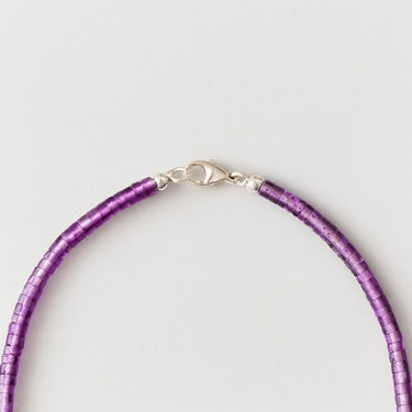 A close-up detail shot of 4mm amethyst heishi beads meeting professional-grade sterling silver hardware, featuring a secure lobster clasp.
