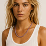 A model wearing a 4mm amethyst round bead necklace, showcasing the vibrant purple stones against a white tank top for an editorial, sophisticated look.

