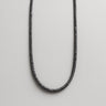 A close-up view of a 4mm Black Lava heishi bead necklace, highlighting the natural volcanic texture and consistent obsidian-matte tone.
