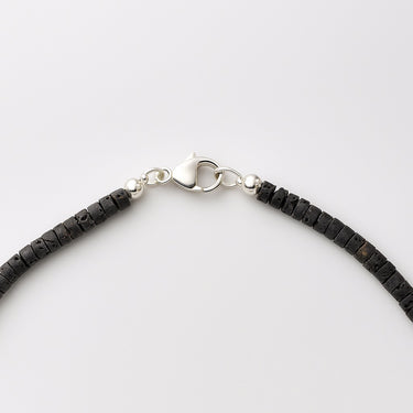 A detailed view of the high-polish sterling silver lobster clasp closure on a 4mm Black Lava heishi bead necklace.
